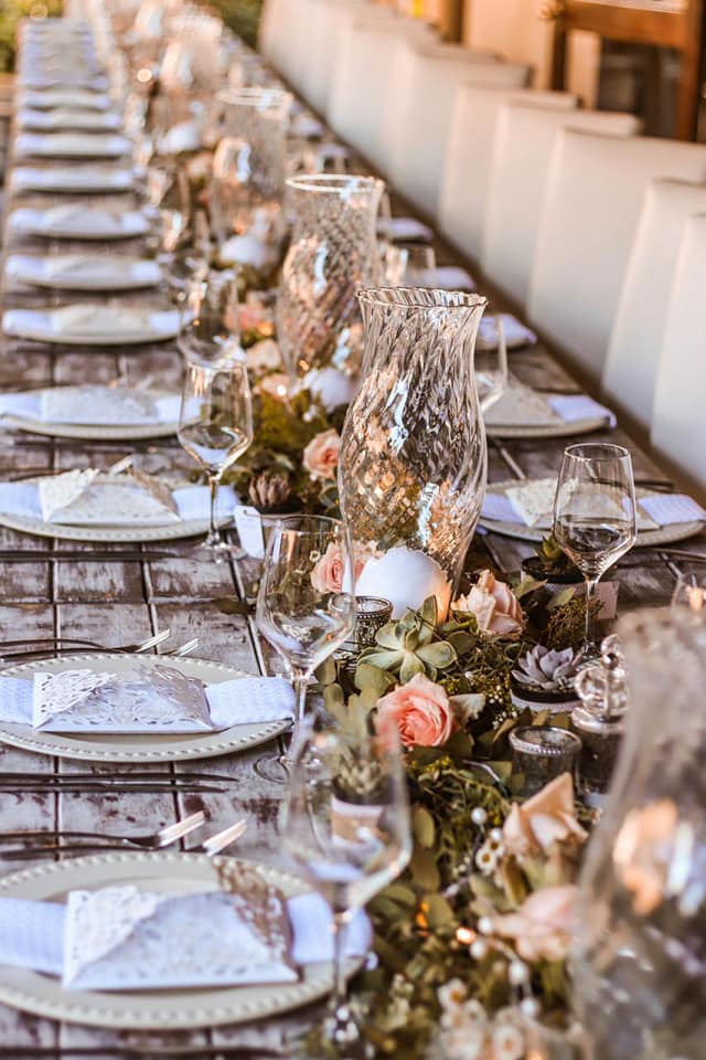 wedding table arrangement of plates and floral display in center of table
